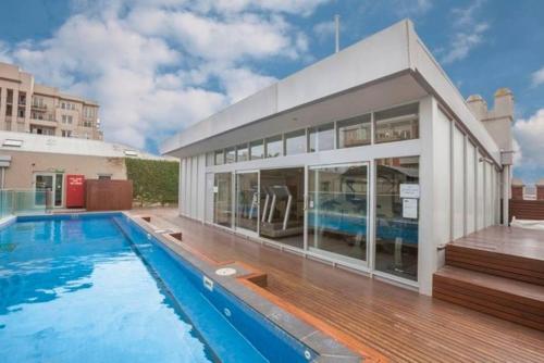 a house with a swimming pool and a building at Easy Eastside - Urban Chic with a Rooftop Pool Oasis in Melbourne