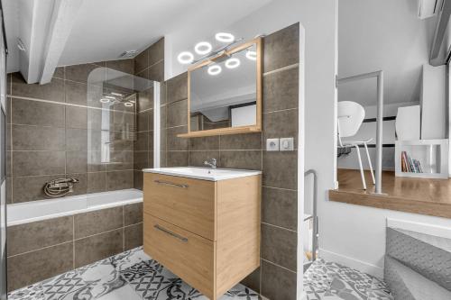 ein Badezimmer mit einem Waschbecken und einer Badewanne in der Unterkunft Le Jardin de Lucette - Belle maison avec jardin arboré dans Toulouse in Toulouse