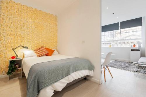 a bedroom with a bed and a yellow wall at Stylish Treetop Escape on Buzzing Swanston Street in Melbourne