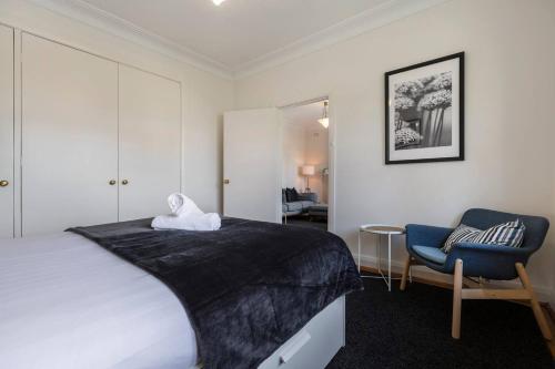 ein Schlafzimmer mit einem großen Bett und einem Stuhl in der Unterkunft Port Phillip Bay Perfection in Albert Park in Melbourne