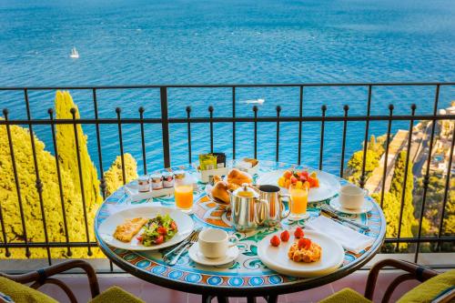 a table with food and a view of the ocean at Grand Hotel San Pietro Taormina in Taormina