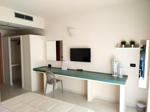Televízia a/alebo spoločenská miestnosť v ubytovaní Hotel Apulia