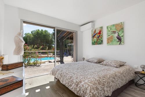 une chambre avec un lit et une vue sur une piscine dans l'établissement Villa Mercure, au Cap d'Agde