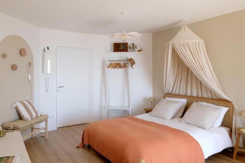 a bedroom with a bed with an orange blanket at Appartement en front de mer avec vue imprenable sur la grande plage des Sables d'Olonne in Les Sables-dʼOlonne