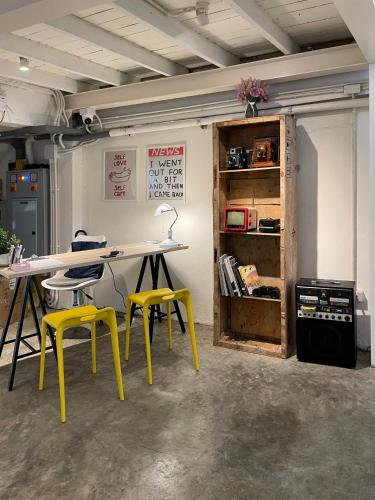 a room with a table and two yellow chairs at Letter Better Home in Bangkok