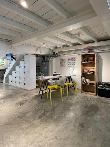 a room with a table and two yellow chairs at Letter Better Home in Bangkok