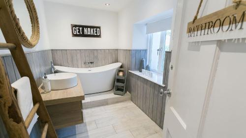 a bathroom with a tub and a sink at The Hideaway Beaumaris in Beaumaris