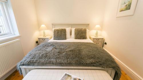 a bedroom with a large bed with two lamps at The Hideaway Beaumaris in Beaumaris