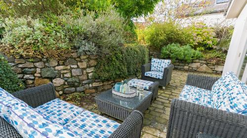 an outdoor patio with wicker chairs and a table at The Hideaway Beaumaris in Beaumaris