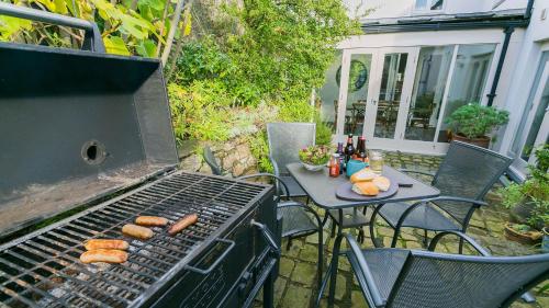 a grill with a table with a plate of food on it at The Hideaway Beaumaris in Beaumaris