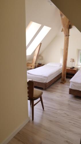a attic bedroom with two beds and a chair at Szewczenki 3 in Olsztyn