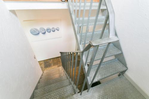 a spiral staircase in a room with vases on the wall at The Moorings in Menai Bridge