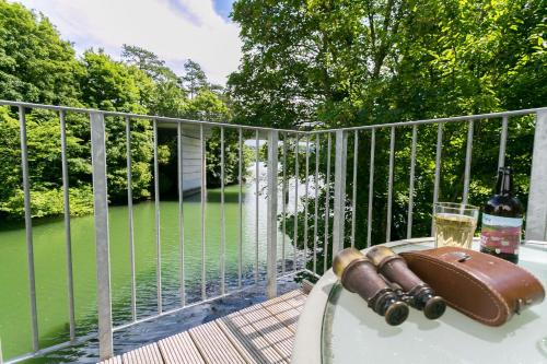 a table with a glass of wine on a balcony at The Moorings in Menai Bridge