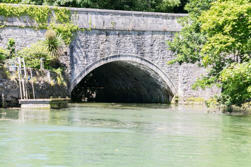 a stone bridge over a river next to trees at The Moorings in Menai Bridge