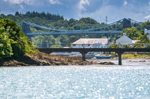 a bridge over a body of water with a river at The Moorings in Menai Bridge
