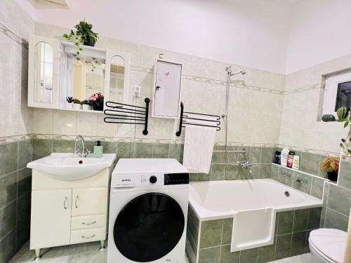 y baño con lavadora, lavamanos y bañera. en Kerepesi City Apartment en Budapest