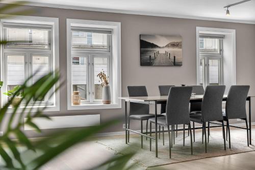 a dining room with a table and chairs and windows at The Urban Cityscape in Tromsø