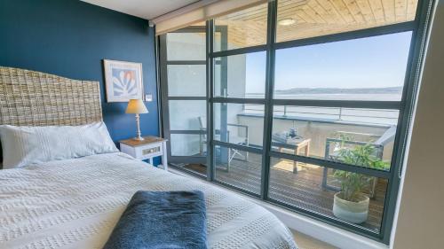 a bedroom with a bed and a large window at The Quay in Benllech