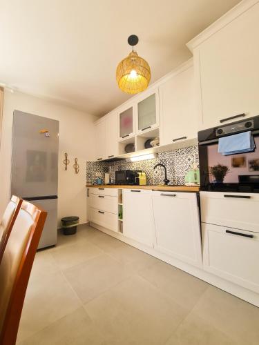 a kitchen with white cabinets and a black appliance at Apartment TORRE - NEW in Senj