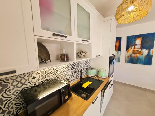 a kitchen with a sink and a microwave at Apartment TORRE - NEW in Senj