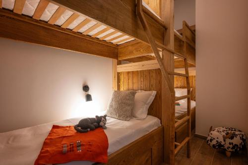 - une chambre avec des lits superposés avec un ours en peluche dans l'établissement Chalet Genepi - Apartment Elsa, aux Gets