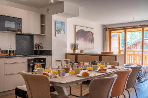 - une salle à manger avec une table, de la nourriture et du jus d'orange dans l'établissement Chalet Genepi - Apartment Elsa, aux Gets