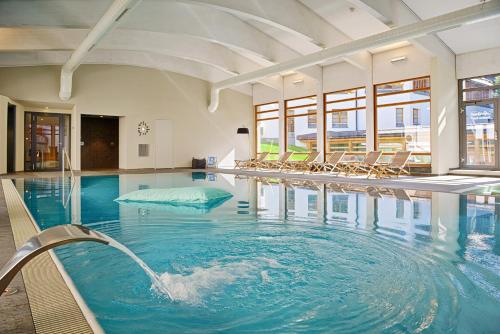 a swimming pool with chairs in a building at Schweizerhof Ferienwohnungen Lenzerheide 4 in Lenzerheide