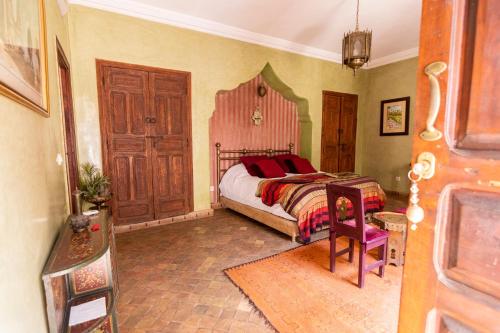 a bedroom with a bed with a wooden headboard at Riad Zayane in Marrakesh