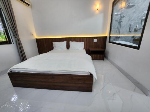 a bedroom with a large bed with white sheets at KL Retreat Hotel in Thanh Hóa