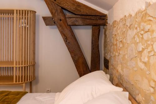a bedroom with a bed and a stone wall at Le Poutic gîte et maison d'hôtes in Créon-dʼArmagnac