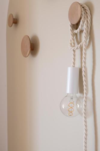 a lamp with a rope attached to a wall at Appartement en front de mer avec vue imprenable sur la grande plage des Sables d'Olonne in Les Sables-dʼOlonne