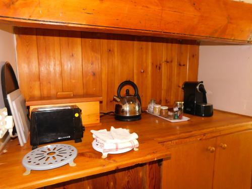 a kitchen counter with a microwave and a tea kettle at De Rusty Farm in De Rust