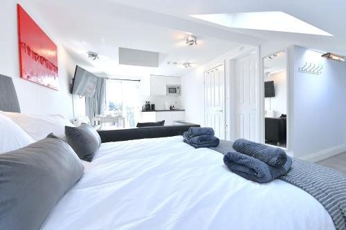 a white bed with blue towels on top of it at Stylish Studios by Luxestays Fulham in London