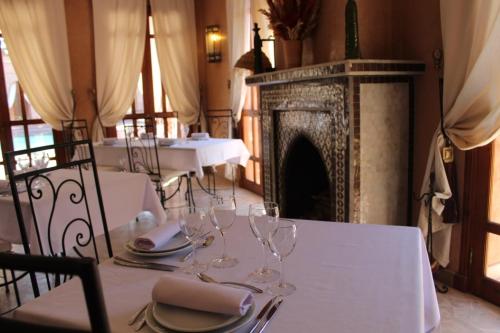a table with wine glasses on it with a fireplace at Domaine Casa Cecilia in Marrakech