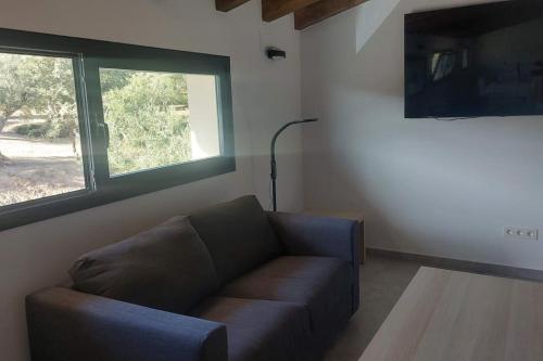 sala de estar con sofá y ventana en Casa rural Atalanta de la Vera en Jaraiz de la Vera