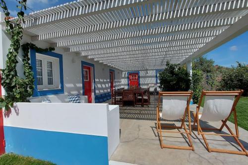 a patio with two chairs under a pergola at Casa Alentejana com piscina e grande jardim 