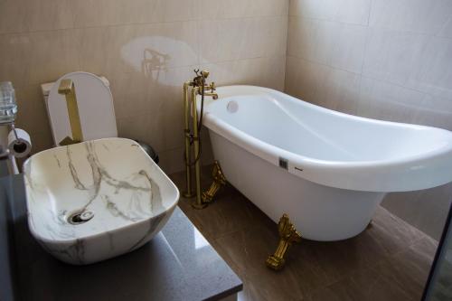 a bathroom with a bath tub and a toilet at Ista Villa in Lusaka