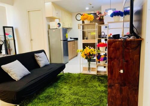 a living room with a couch and a green rug at Studio 7th FL with Balcony across Terminal 3 Airport in Manila