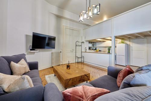 un salon avec deux canapés et une table basse dans l'établissement Bord de Mer - Charmant studio vue mer, à Trouville-sur-Mer