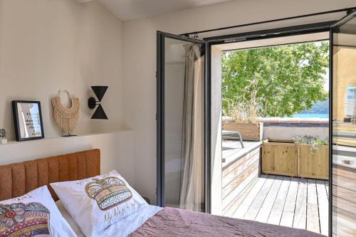 - une chambre avec un lit et une porte coulissante en verre dans l'établissement La plage et les commerces à pieds !, à Saint-Cyr-sur-Mer