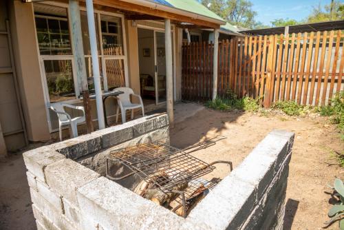 a brick retaining wall in front of a house at De Rusty Farm in De Rust