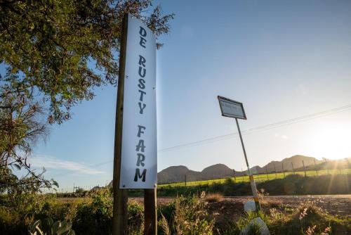 a sign for a restaurant on the side of a road at De Rusty Farm in De Rust