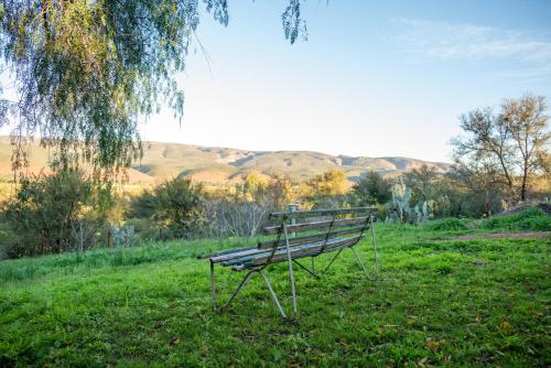a park bench sitting in the grass in a field at De Rusty Farm in De Rust