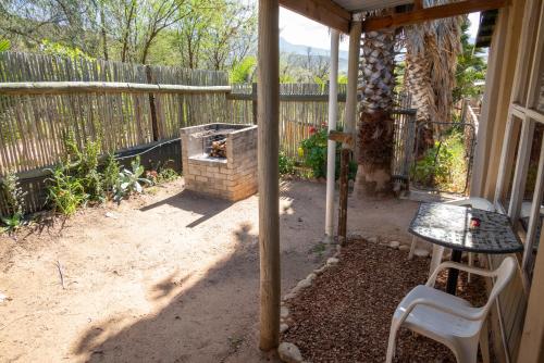 a patio with a table and a chair next to a fence at De Rusty Farm in De Rust