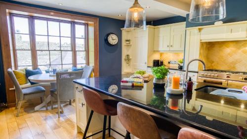 a kitchen with a counter and a dining room at Ty Castell in Beaumaris