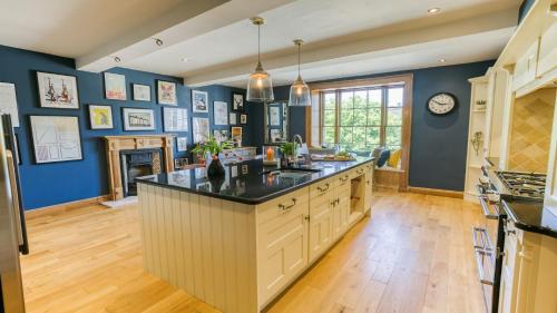 a large kitchen with blue walls and a large island at Ty Castell in Beaumaris