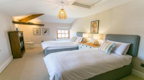 a bedroom with two beds and a table with lamps at Ty Castell in Beaumaris