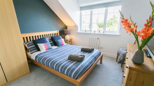 a bedroom with a bed with pillows and a window at Anchor Cottage in Cemaes Bay