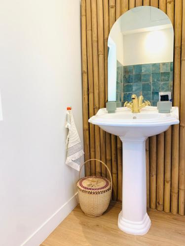 une salle de bain avec un lavabo et un miroir dans l'établissement Le gîte d ici et d ailleurs Ariège Pyrénées, à Baulou