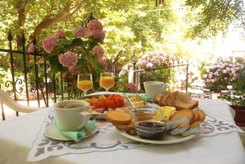 a table with a plate of food and two glasses of wine at Orpheus Hotel in Therma